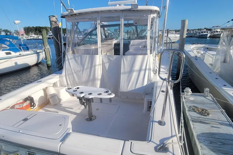 Valkyrie Yacht Photos Pics 2004 Pursuit 3400 Offshore boat docked, featuring spacious deck and fishing rod holders.