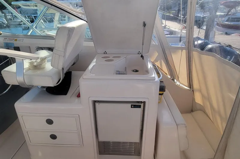 Valkyrie Yacht Photos Pics 2004 Pursuit 3400 Offshore boat interior with helm seat and kitchenette area.