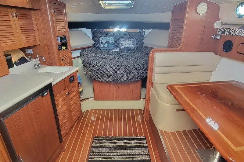 Valkyrie Yacht Photos Pics 2004 Pursuit 3400 Offshore cabin interior with wood finishes and cozy sleeping area.