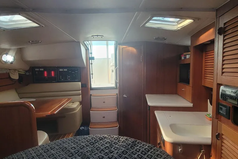 Valkyrie Yacht Photos Pics 2004 Pursuit 3400 Offshore cabin interior with wood finishes and seating area.