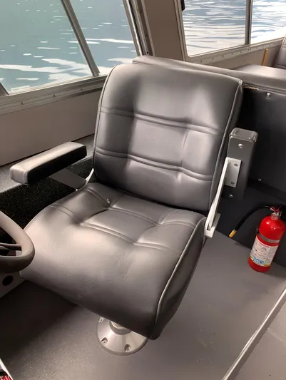  Yacht Photos Pics Captain's chair in a 2005 Coastal Craft 32 boat interior, with a fire extinguisher nearby.