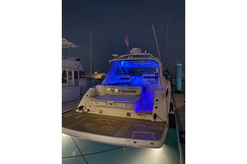  Yacht Photos Pics 2010 Sea Ray 450 Sundancer yacht docked at night with blue interior lighting.