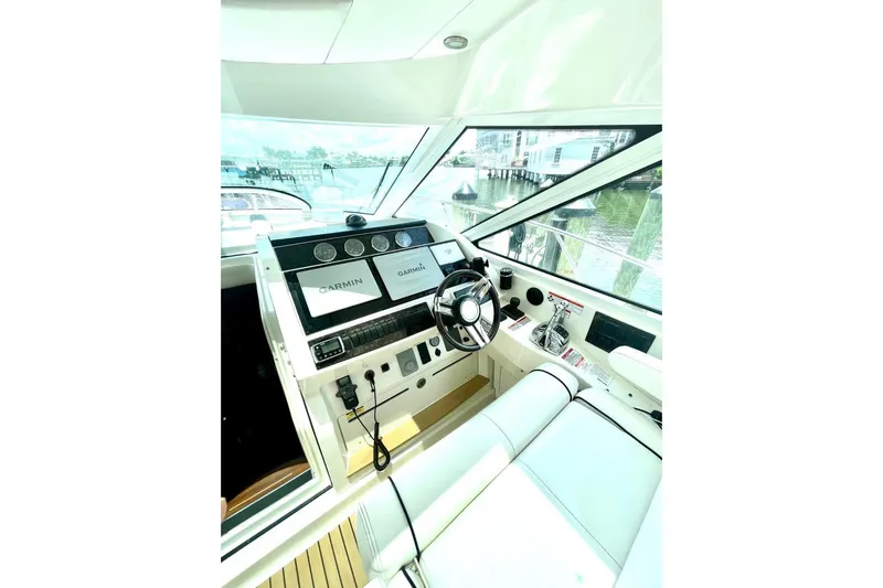  Yacht Photos Pics Helm of 2010 Sea Ray 450 Sundancer with Garmin navigation system, docked by the water.