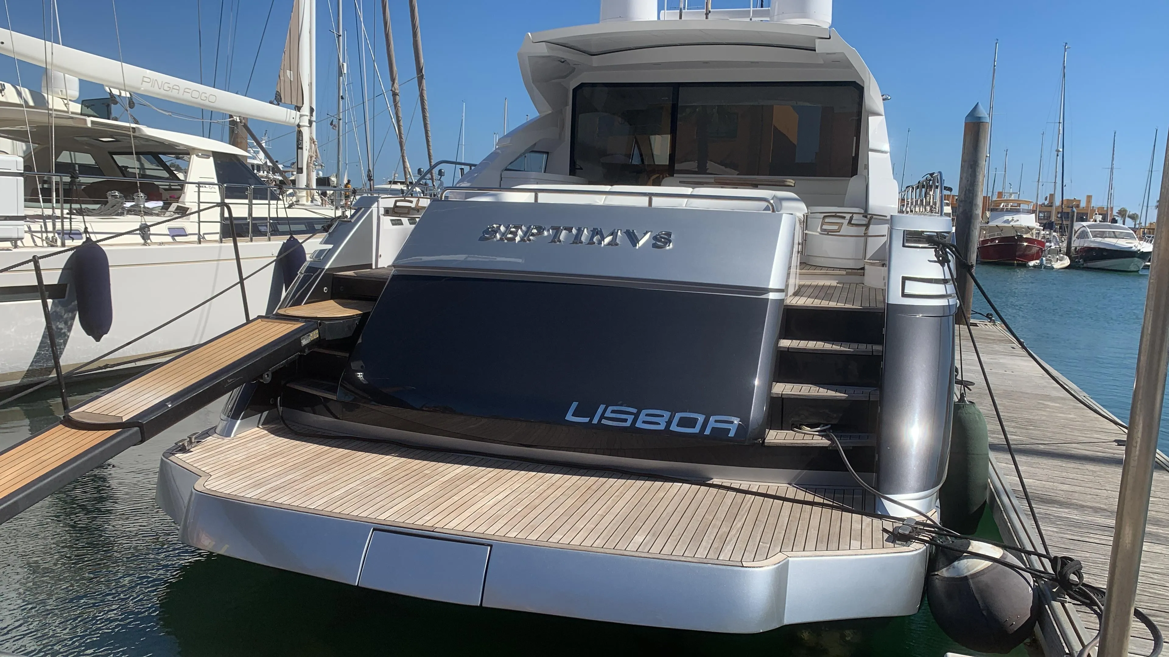 2010 Pershing 64 yacht docked at marina, rear view with "Lisboa" nameplate.