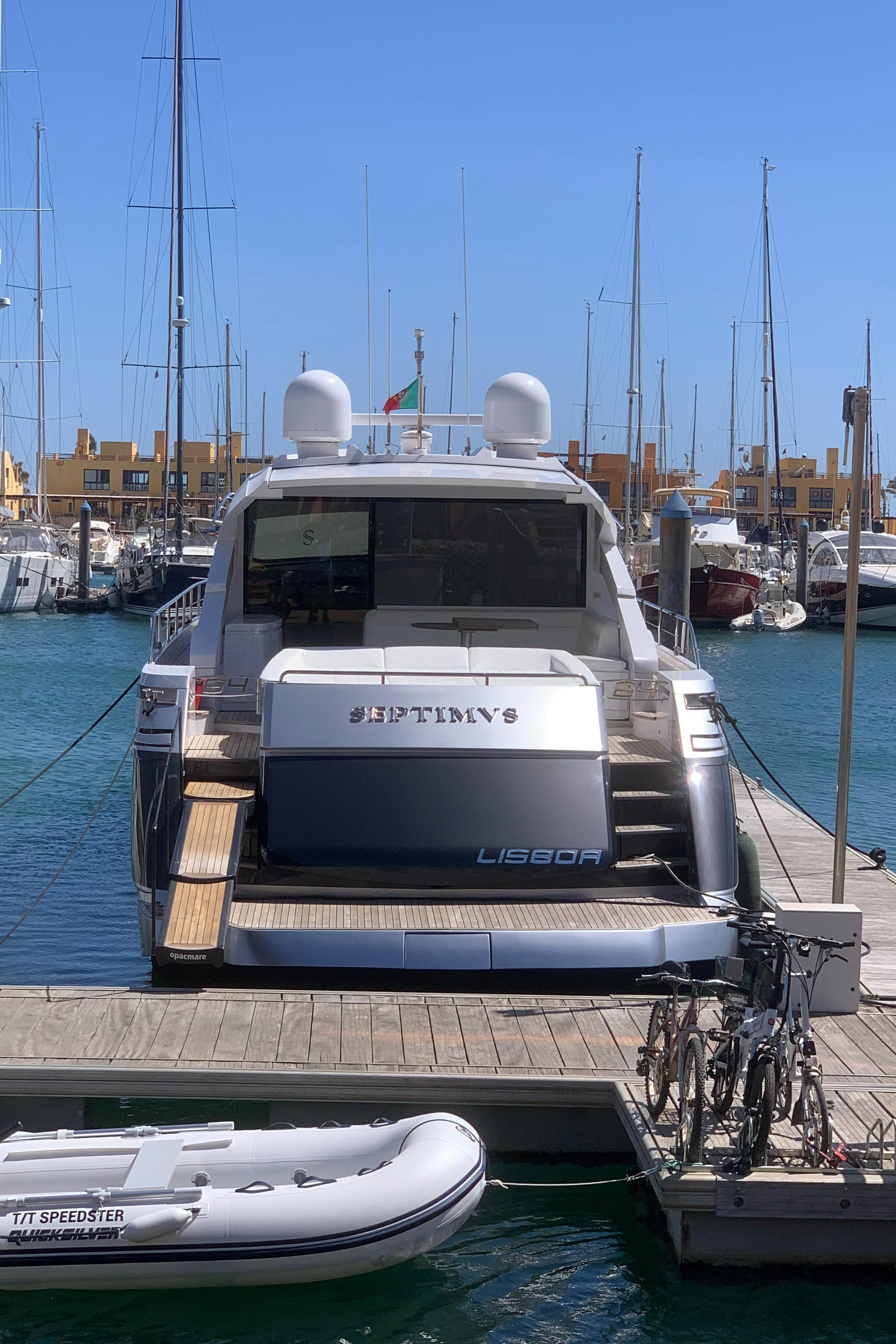2010 Pershing 64 yacht docked at marina with clear blue sky.