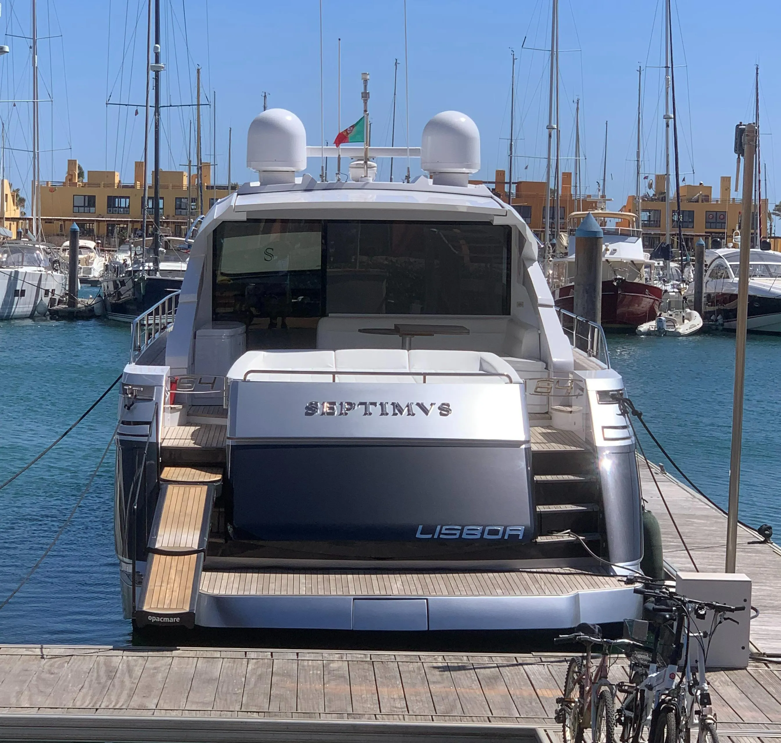 2010 Pershing 64 yacht docked at marina with clear blue sky.