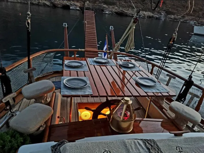  Yacht Photos Pics Classic 1982 Schooner 17m with elegant outdoor dining setup, docked by serene waters.