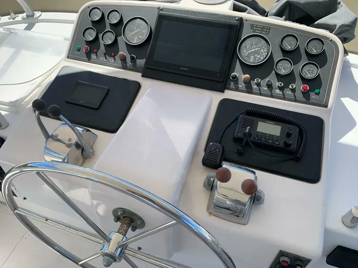 Sundog Yacht Photos Pics 1996 Ocean Alexander 423 Classico boat helm with steering wheel, gauges, and navigation equipment.