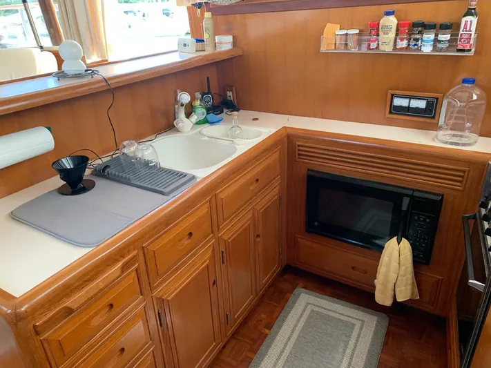 Sundog Yacht Photos Pics 1996 Ocean Alexander 423 Classico yacht kitchen with microwave, sink, and wooden cabinets.
