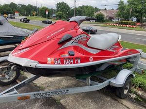 2006 Yamaha WaveRunner VX 110 Deluxe in red on trailer, parked outdoors.