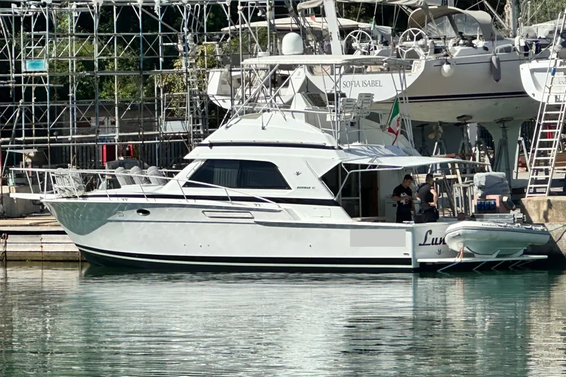  Yacht Photos Pics 1988 Bertram 43 Convertible yacht docked at marina with people onboard.