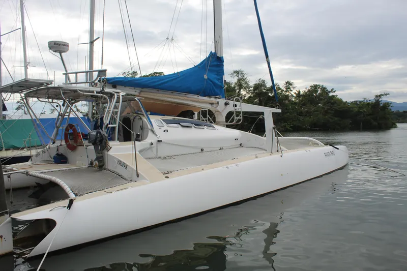 Panta Rhei Yacht Photos Pics Custom Roake 50 catamaran, 2012 model, docked on calm water with blue sail cover.