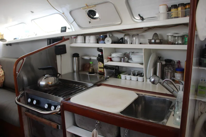 Panta Rhei Yacht Photos Pics Compact kitchen in 2012 Custom Roake 50 yacht with stove, sink, and storage shelves.