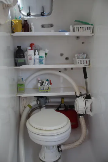 Panta Rhei Yacht Photos Pics Compact marine bathroom with shelves, toiletries, and manual toilet on a 2012 Custom Roake 50 boat.