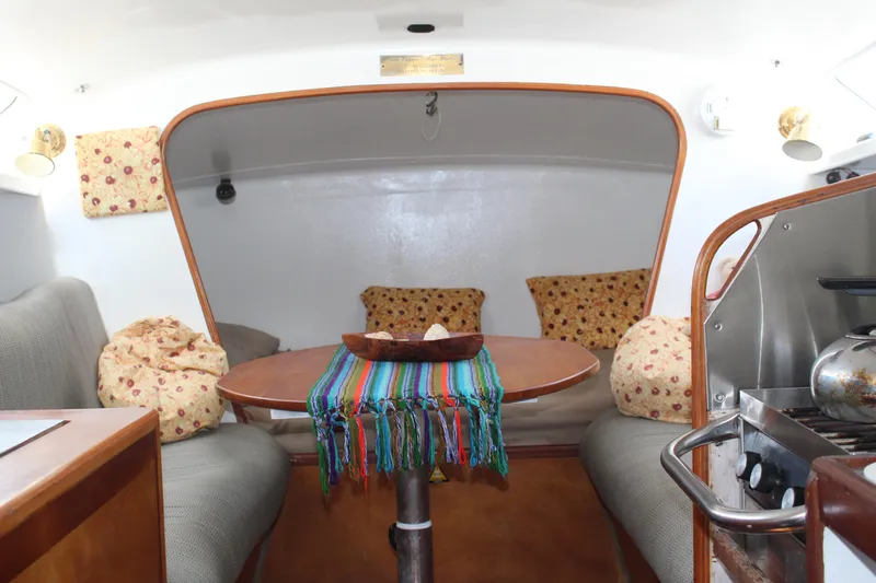 Panta Rhei Yacht Photos Pics Cozy interior of 2012 Custom Roake 50 sailboat with colorful tablecloth and cushions.