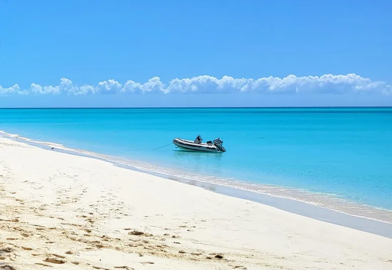 Ohana Yacht Photos Pics Inflatable boat on tropical beach with turquoise water.