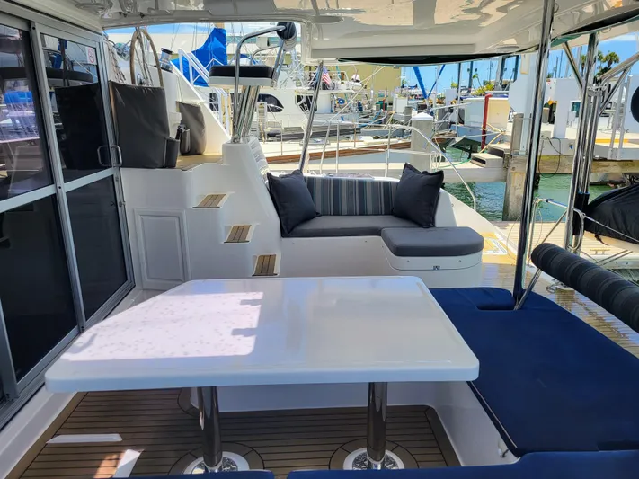 Ohana Yacht Photos Pics Leopard 44 Yacht, 2016, featuring comfortable outdoor seating and table at the marina.