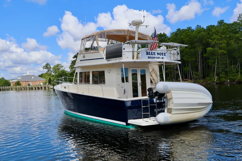 Blue Note Yacht Photos Pics 2007 Mainship 430 Trawler "Blue Note" on serene water, surrounded by lush greenery.