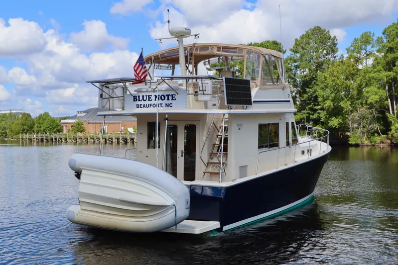 Blue Note Yacht Photos Pics 2007 Mainship 430 Trawler on water, featuring solar panels and an inflatable boat.