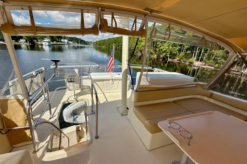 Blue Note Yacht Photos Pics 2007 Mainship 430 Trawler interior with seating, table, and scenic waterway view.
