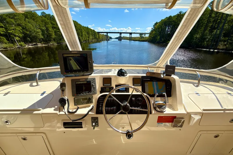 Blue Note Yacht Photos Pics 2007 Mainship 430 Trawler helm with navigation equipment, cruising on a scenic river.