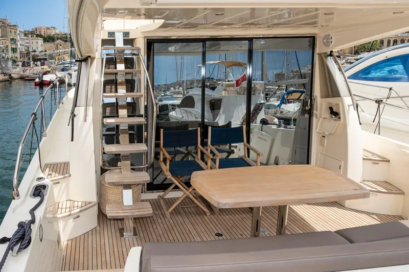 Yacht Photos Pics Luxurious 2019 Prestige 500 yacht deck with seating and table, docked in a marina.