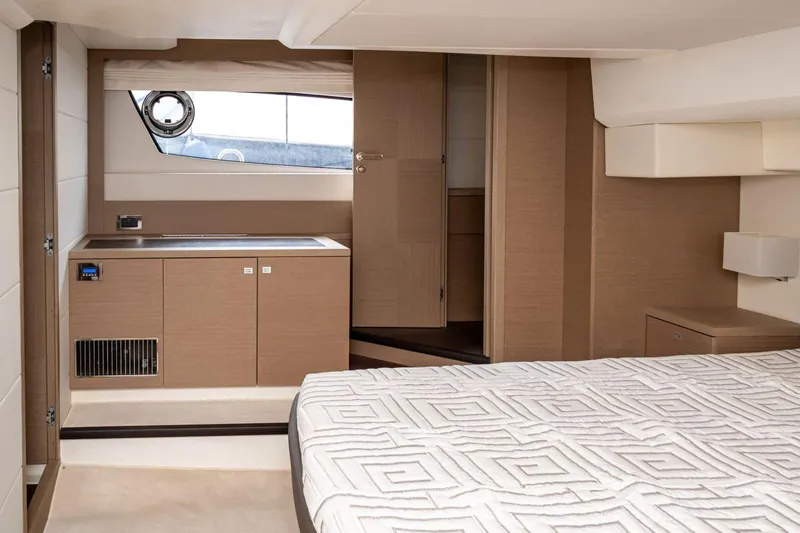  Yacht Photos Pics Luxurious interior of 2019 Prestige 500 yacht with modern wood finishes and elegant bedding.