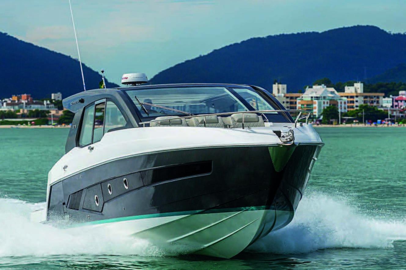 2025 Schaefer 375 HT yacht cruising on water with cityscape and mountains in background.