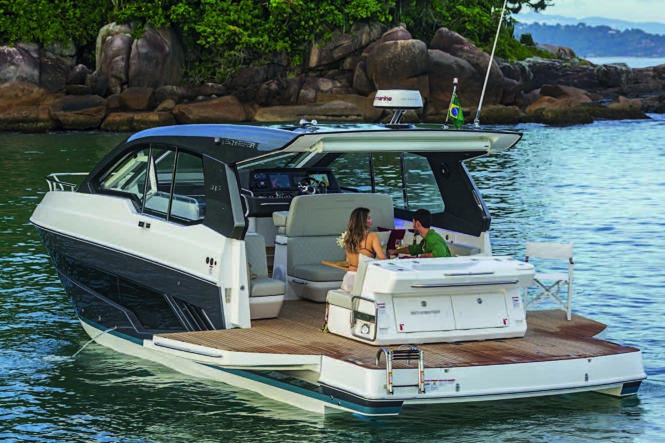 2025 Schaefer 375 HT yacht cruising near lush coastline, featuring a couple enjoying the deck.