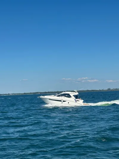  Yacht Photos Pics 2021 Sea Ray Sundancer 350 Coupe cruising on open water under clear blue sky.