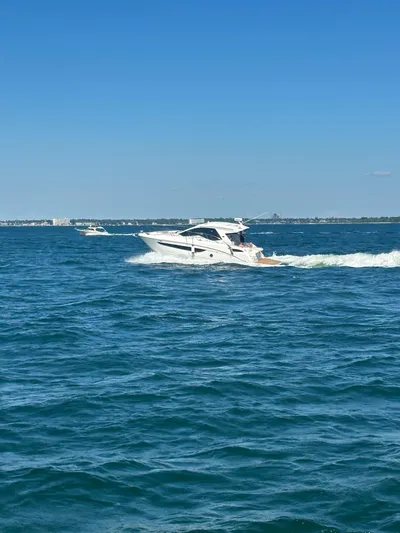  Yacht Photos Pics 2021 Sea Ray Sundancer 350 Coupe cruising on open water under clear blue skies.