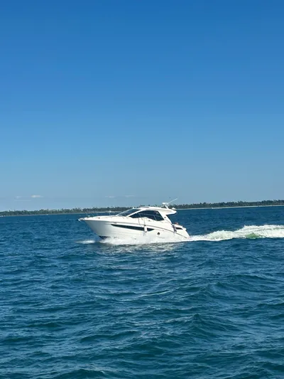  Yacht Photos Pics 2021 Sea Ray Sundancer 350 Coupe cruising on open water under clear blue skies.