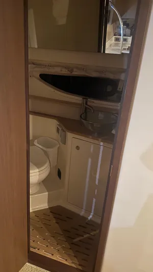  Yacht Photos Pics 2021 Sea Ray Sundancer 350 Coupe bathroom interior with modern fixtures and wooden accents.