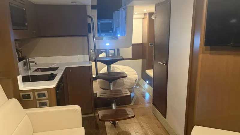  Yacht Photos Pics Interior of 2021 Sea Ray Sundancer 350 Coupe, featuring modern kitchen and cozy seating area.