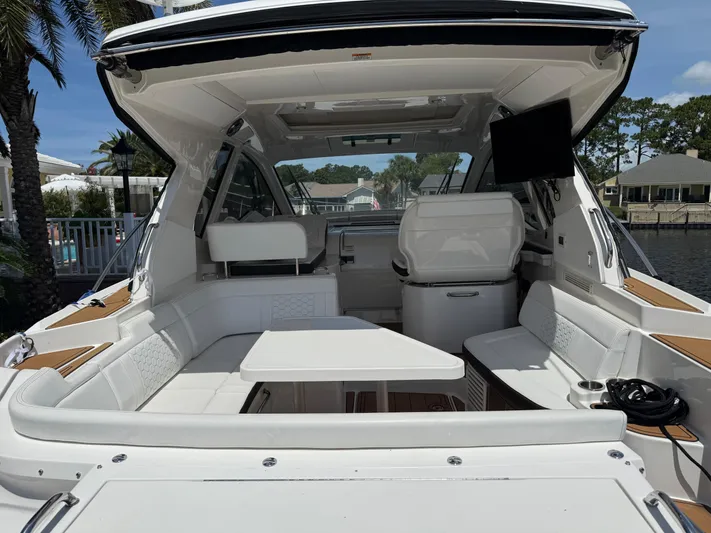  Yacht Photos Pics 2021 Sea Ray Sundancer 350 Coupe interior with seating and table, docked by waterfront homes.