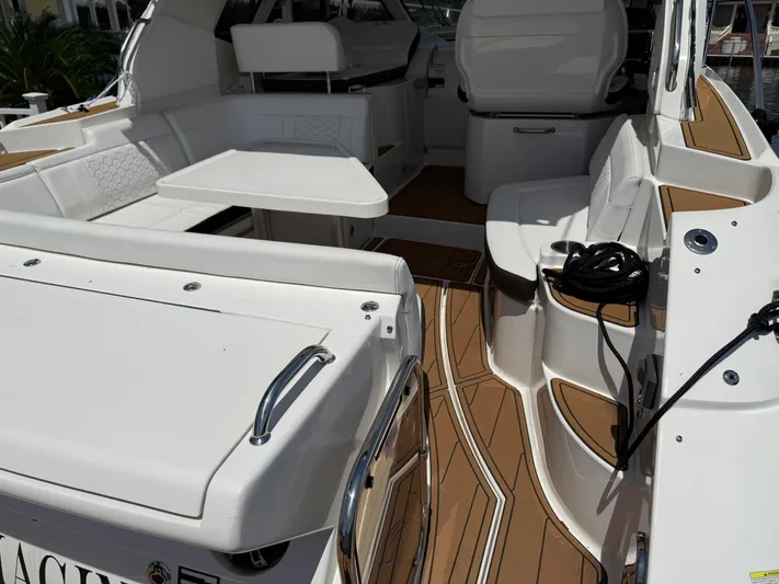  Yacht Photos Pics 2021 Sea Ray Sundancer 350 Coupe interior with white seating and wooden flooring.
