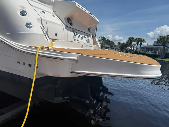  Yacht Photos Pics 2021 Sea Ray Sundancer 350 Coupe docked, featuring a spacious swim platform and scenic waterfront view.