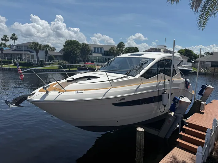  Yacht Photos Pics 2021 Sea Ray Sundancer 350 Coupe docked by waterfront homes under a clear sky.