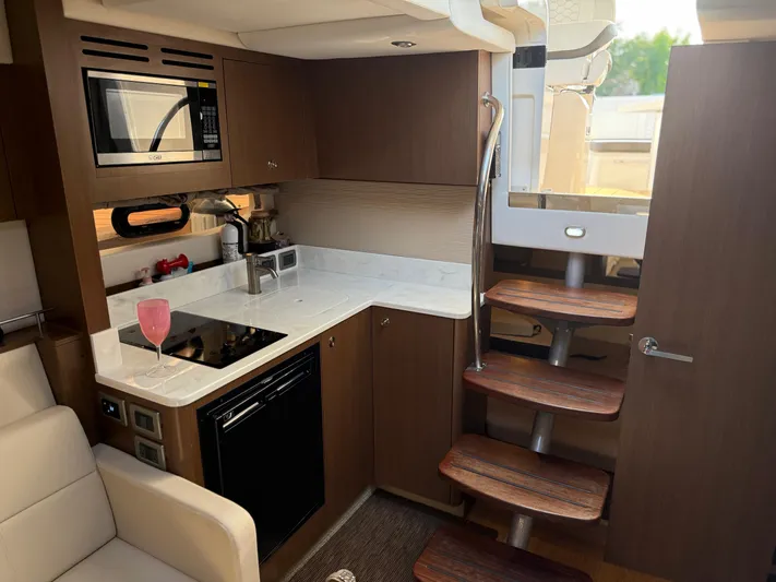  Yacht Photos Pics Interior of 2021 Sea Ray Sundancer 350 Coupe with modern kitchen and wooden stairs.