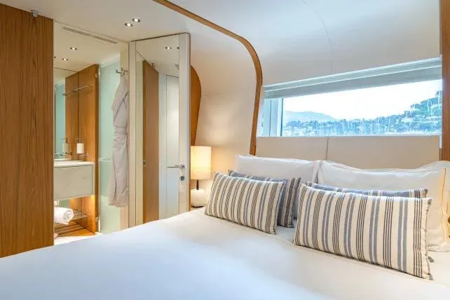 Yacht Photos Pics Luxurious bedroom interior of 2023 Benetti Motopanfilo 37M yacht with striped pillows and scenic window view.