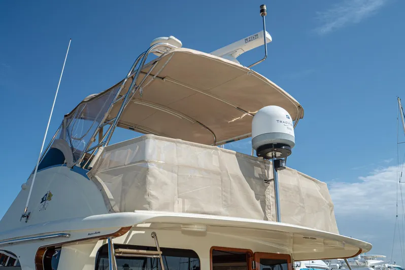 Nick Of Time Yacht Photos Pics 2007 Midnight Lace Sport Cruiser yacht with canopy and radar, under clear blue sky.