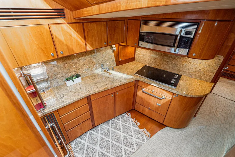 Nick Of Time Yacht Photos Pics Luxurious 2007 Midnight Lace Sport Cruiser kitchen with wood cabinetry and granite countertops.