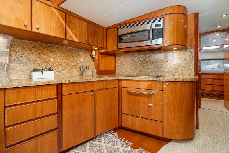 Nick Of Time Yacht Photos Pics Luxurious 2007 Midnight Lace Sport Cruiser kitchen with wood cabinetry and granite countertops.