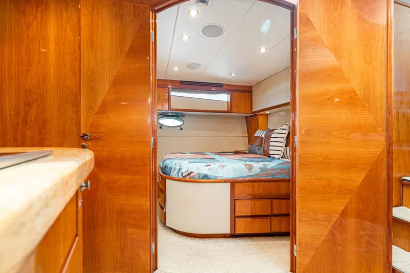 Nick Of Time Yacht Photos Pics Luxurious cabin interior of 2007 Midnight Lace Sport Cruiser with wooden finishes and cozy bedding.