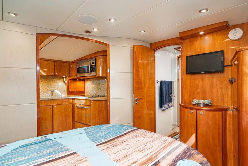 Nick Of Time Yacht Photos Pics Luxurious 2007 Midnight Lace Sport Cruiser interior with wood finishes, kitchenette, and TV.