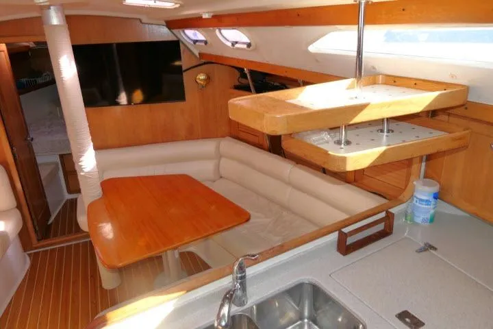 Right Action Yacht Photos Pics Interior of 2008 Catalina 400 MK II sailboat with cozy seating and wooden table.