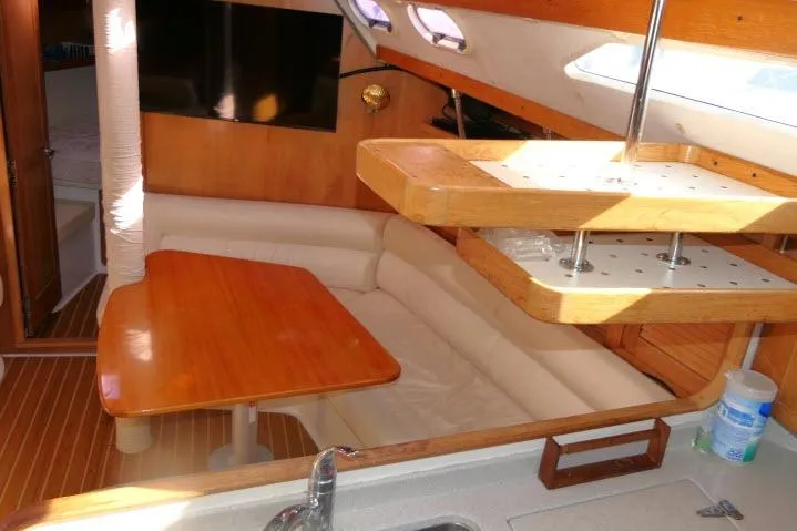 Right Action Yacht Photos Pics Interior of 2008 Catalina 400 MK II sailboat with wooden table and seating area.