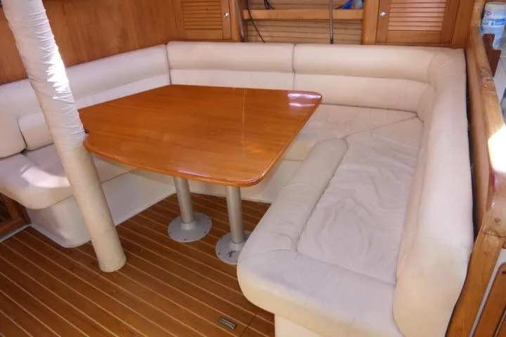 Right Action Yacht Photos Pics Cozy dining area in 2008 Catalina 400 MK II yacht with wooden table and cushioned seating.