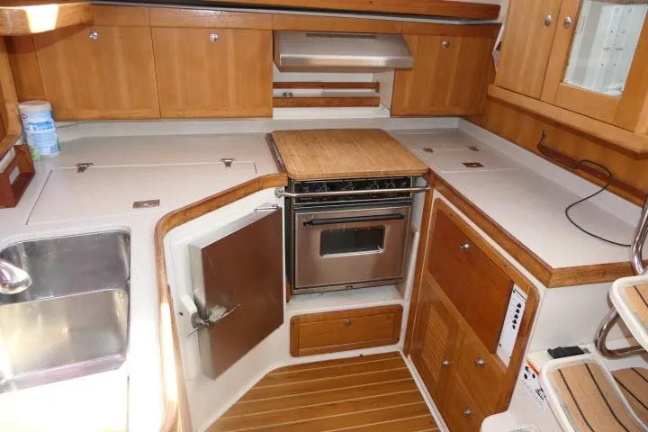 Right Action Yacht Photos Pics 2008 Catalina 400 MK II yacht kitchen with wooden cabinets and stainless steel appliances.