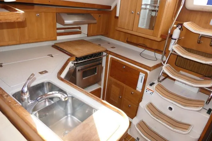 Right Action Yacht Photos Pics Interior of 2008 Catalina 400 MK II yacht kitchen with wooden cabinetry and stainless steel sink.